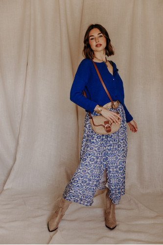 Femme avec une jupe longue et un pull bleu.