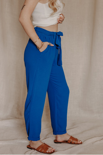 Femme de profil avec un pantalon bleu.