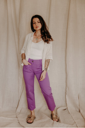 femme qui porte un pantalon violet et une surchemise brodée