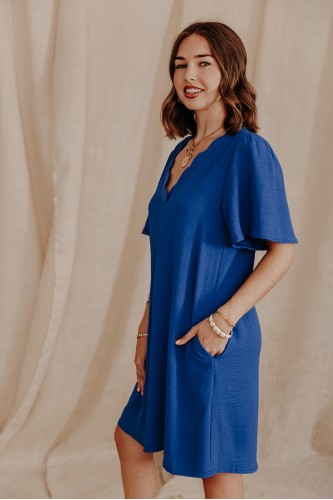 Femme de profil qui porte une robe bleue unie