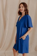 Femme de profil qui porte une robe bleue unie