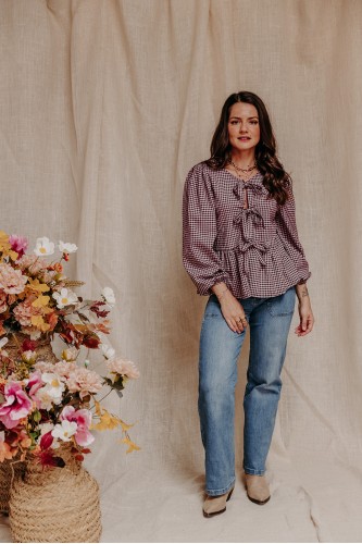 femme debout qui porte une blouse vichy et un jean large