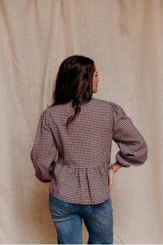 femme de dos qui porte une blouse vichy et un jean