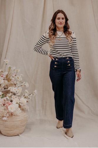 femme debout qui porte un pull marinière et un jean taille haute