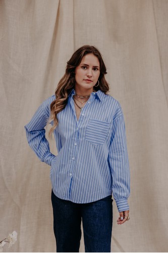 Femme qui porte une chemise bleue à rayures.