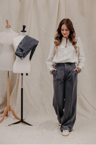 Femme avec une chemise à carreaux et un pantalon.