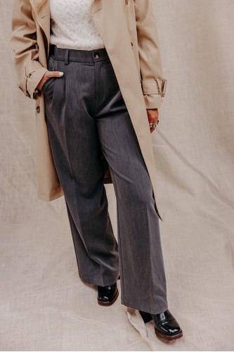 Femme avec un pantalon et un trench.