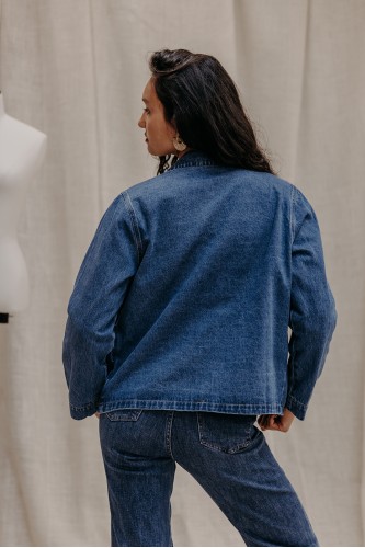 Femme de dos avec une veste en jean.