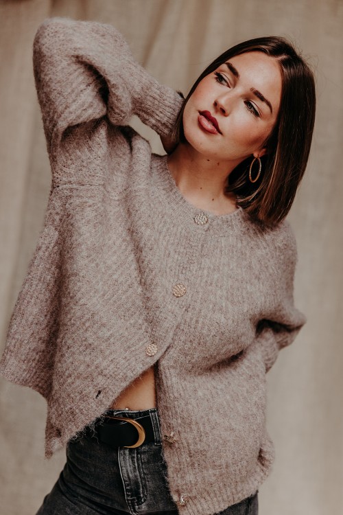 Femme avec un pull couleur taupe.