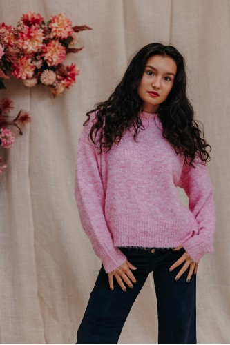 Femme portant un pull rose.