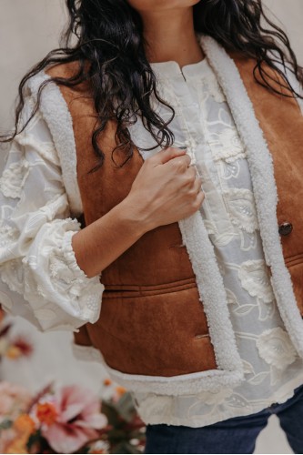 Femme avec un gilet camel.