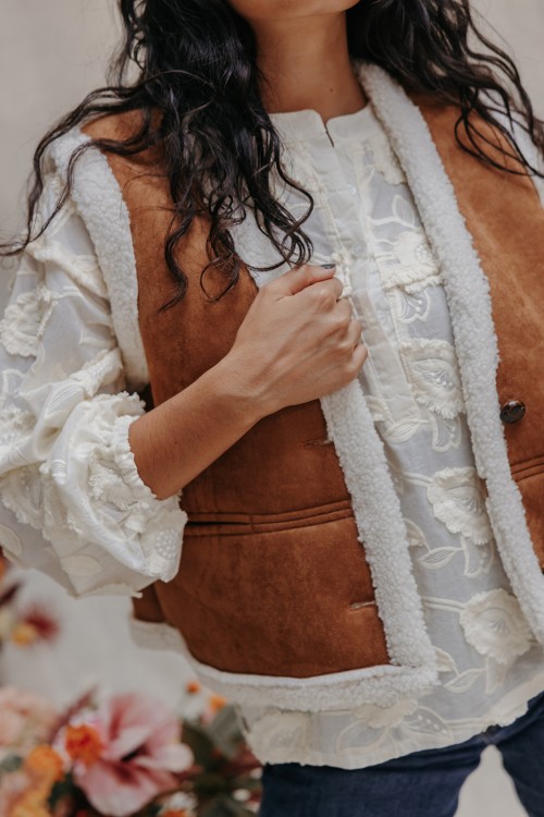 Femme avec un gilet camel.