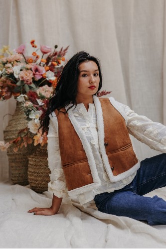 Femme assise avec un gilet.