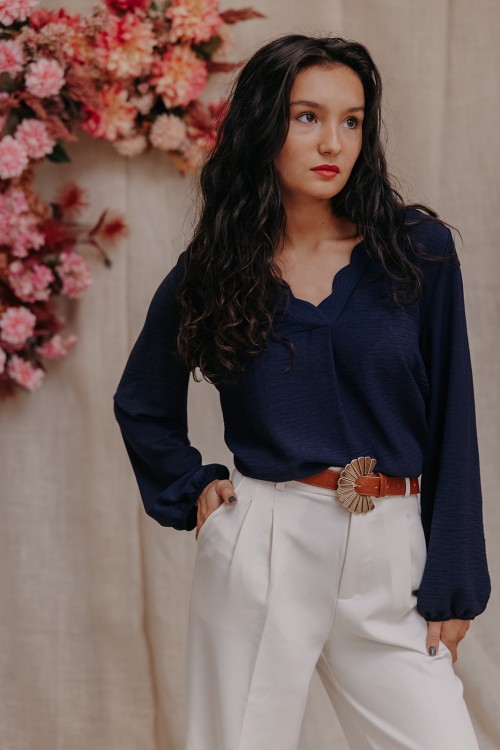 Femme avec un look composé d'une blouse bleu.