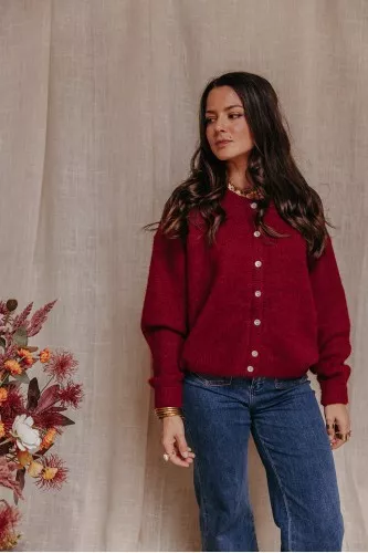 Femme avec un cardigan bordeaux.