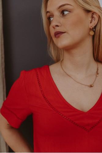 Détails d'une blouse rouge unie portée par une femme