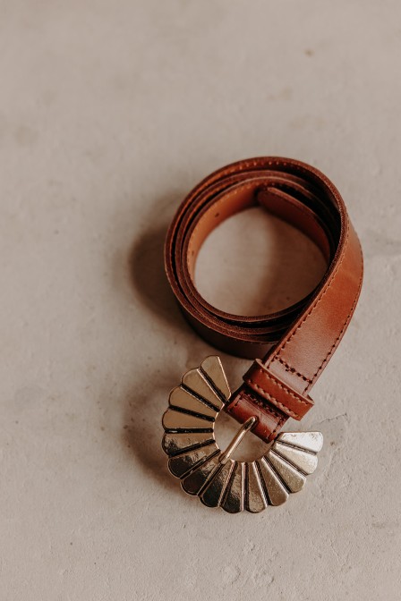 Ceinture cognac avec une boucle dorée.