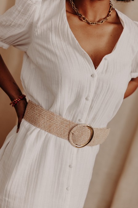 Femme avec une ceinture sur une robe.