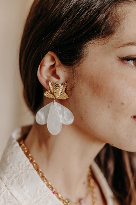 Femme qui porte des boucles d'oreilles lotus.