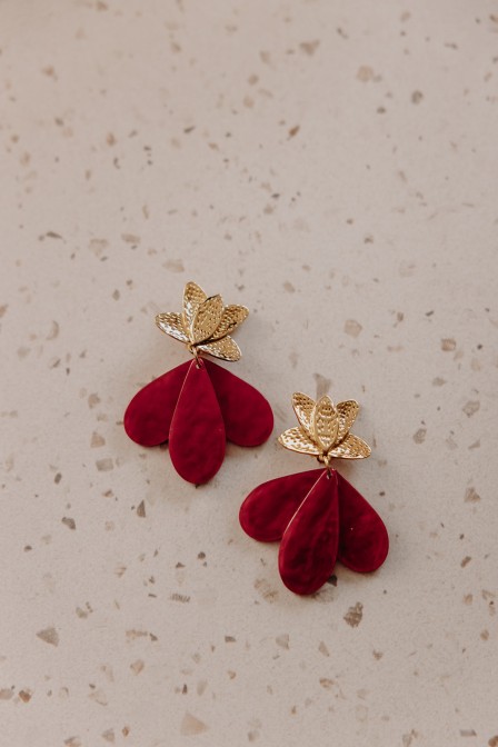 Boucles d'oreilles rouges et dorées posées.