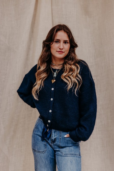 Femme qui porte un gilet cardigan bleu.