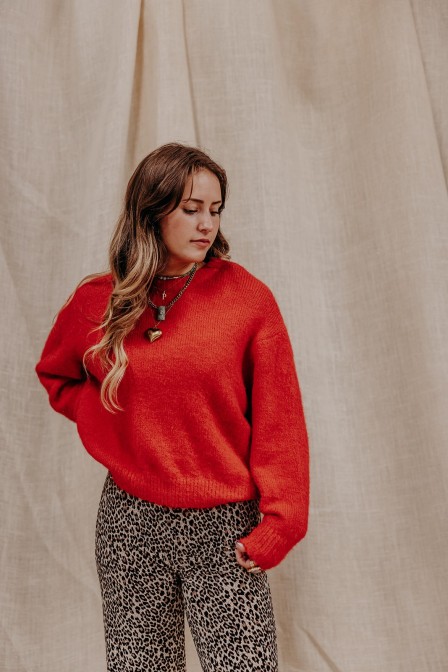 Femme avec un pull rouge.