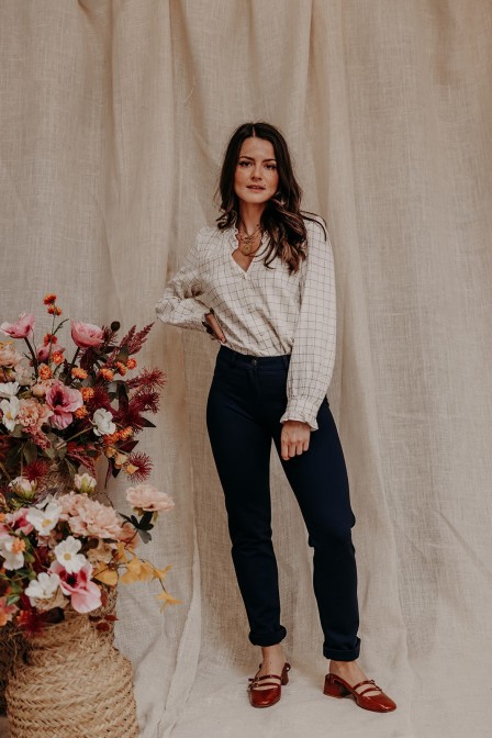 Femme avec un pantalon marine et une blouse.