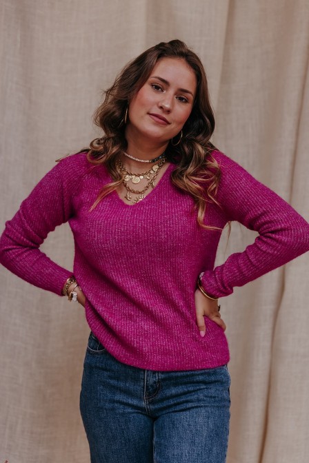 Femme avec un pull en mail rose.