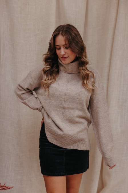 Pull beige porté par une femme.