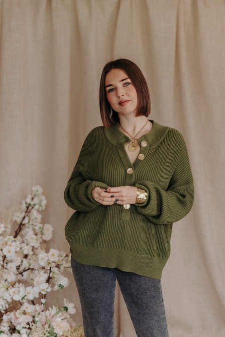 Femme avec le pull vert ressorti du pantalon