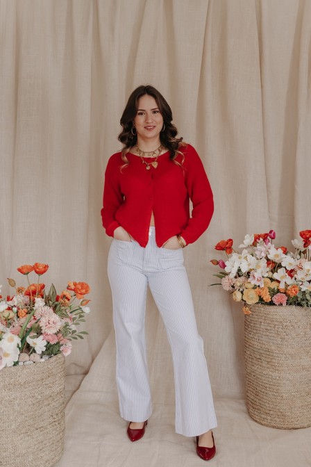 Femme portant un jean large avec un pull rouge.