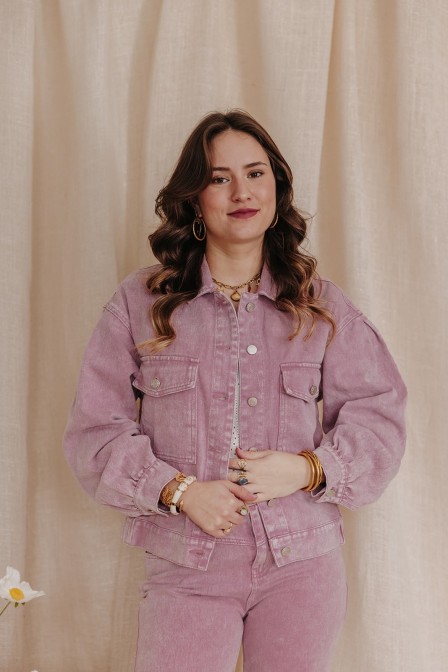 Femme avec une veste en jean rose.