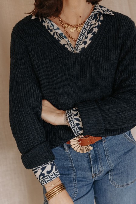 Femme avec un pull col V bleu marine.