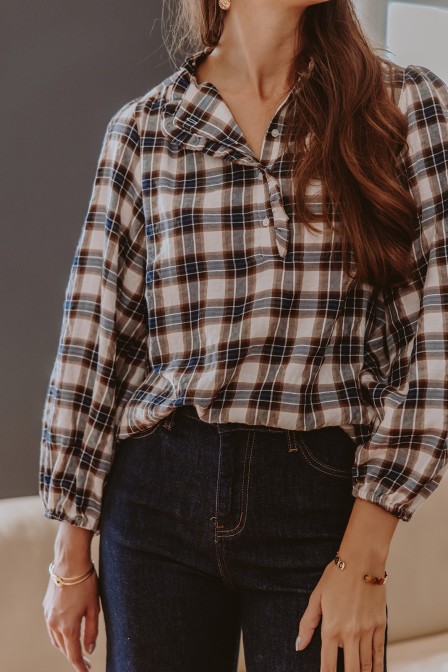 Femme qui porte une blouse à carreaux.