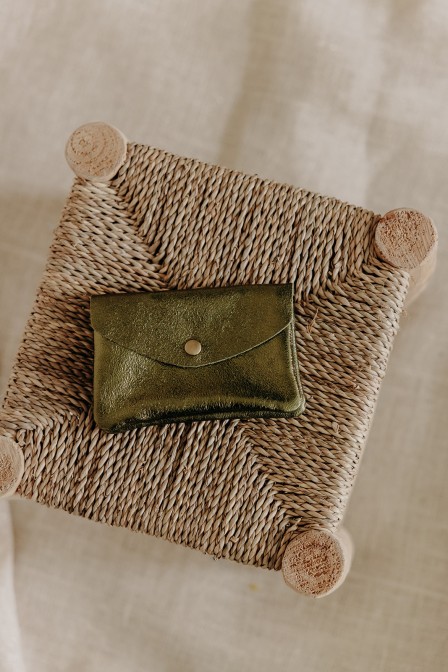 Pochette olive sur un tabouret.